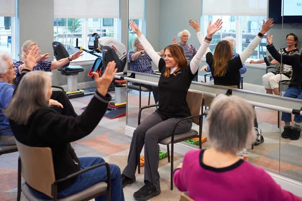 Residents participating in a seated exercise class