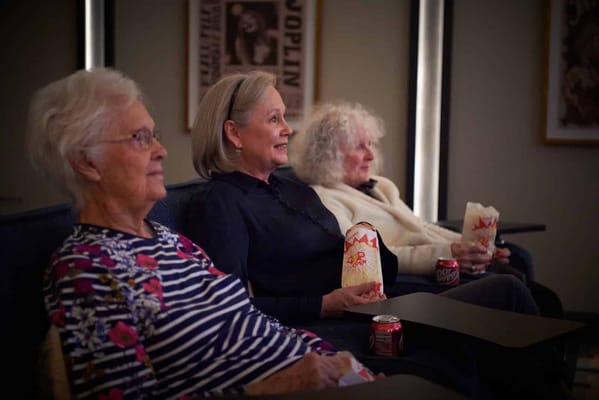 Residents enjoying a movie with popcorn and drinks