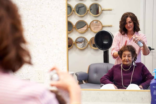 Staff member styling resident's hair in salon