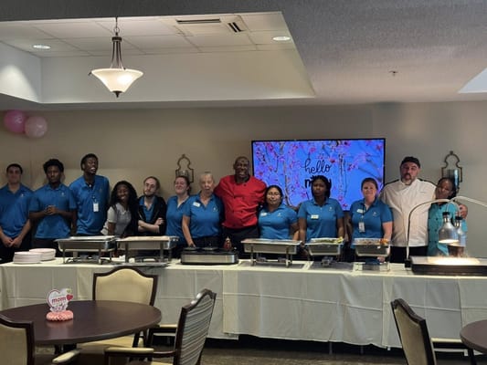 Staff and residents at a dining event with food service