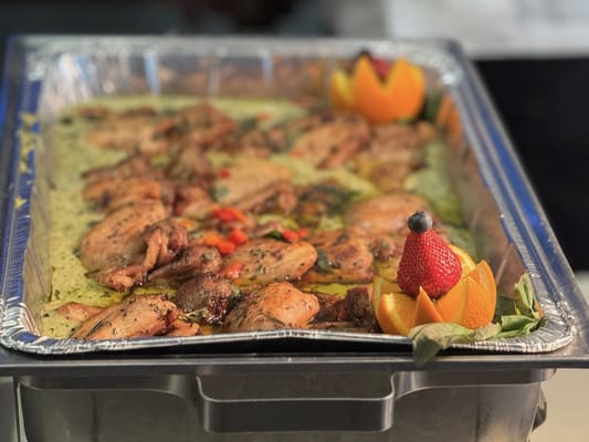 Close-up of a beautifully presented chicken dish with fruit garnishes