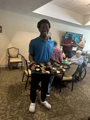Staff serving dessert to residents in a common area