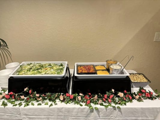 Buffet setup with salad and various food items