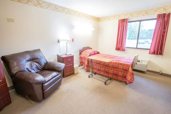 Cozy resident room with bed and chair