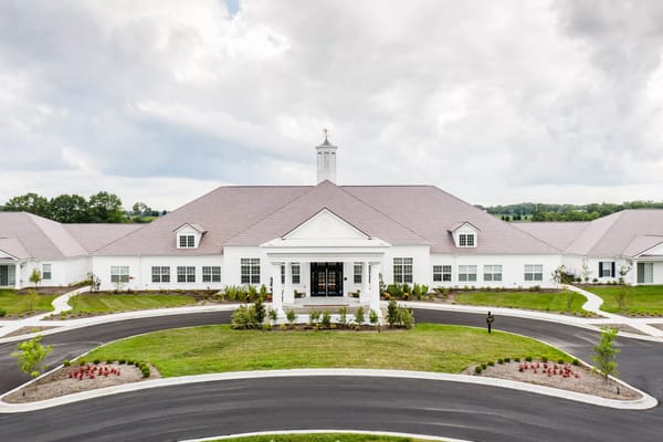 Front facade of Ashton Grove senior living facility with landscaped gardens.