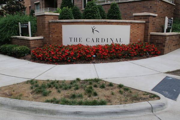 Exterior sign of The Cardinal at North Hills with flowers