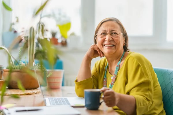 Senior woman smiling with a cup of coffee in a cozy setting