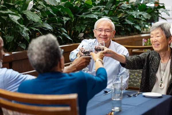 Residents toasting glasses in a dining room