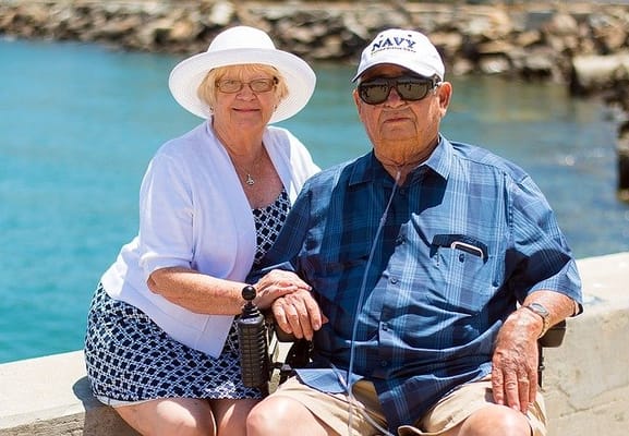 An elderly couple enjoying their time by the water