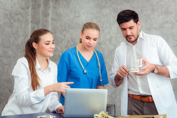 Healthcare staff collaborating over a laptop