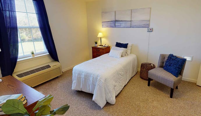 Cozy private resident room with a bed and chair