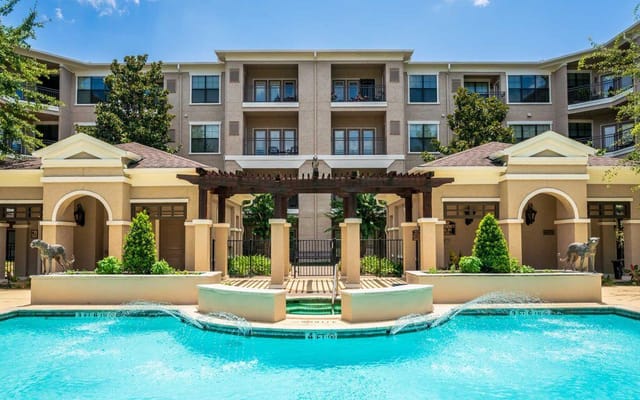Outdoor pool area with fountain in front of the building