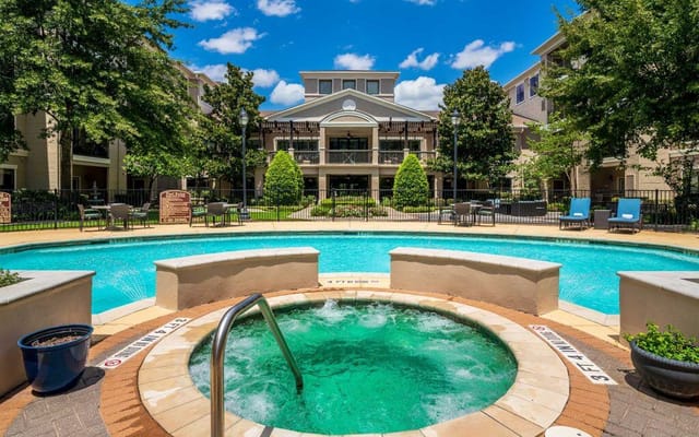 Outdoor swimming pool area with spa and seating