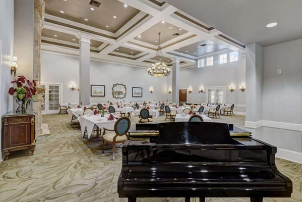 Interior view of an elegant dining room with tables and a piano