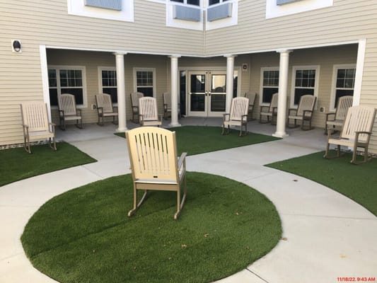 Outdoor seating area with green turf and chairs