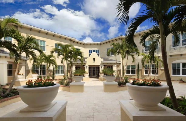 Beautiful courtyard with planters and palm trees at Bayshore Memory Care.