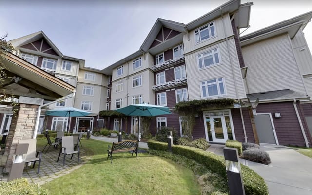 Exterior view of a senior living facility with outdoor seating