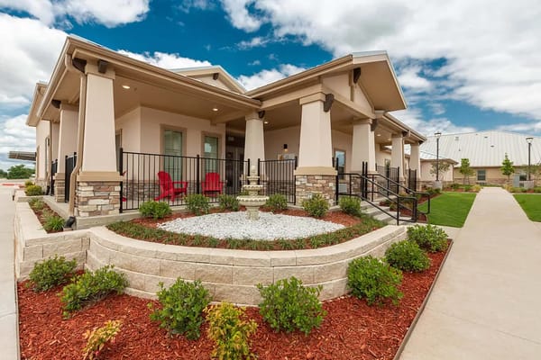 Exterior view of a senior living facility with landscaped gardens