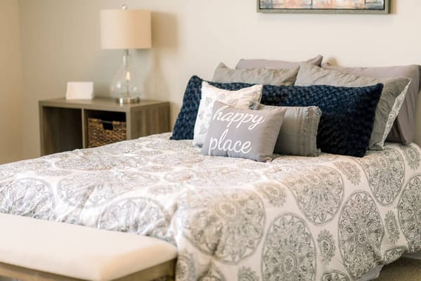 A cozy bedroom setting with pillows and decor