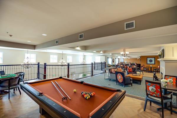 Residents enjoying games in a common area with pool table