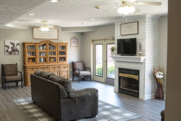 Cozy lounge with seating and a bookshelf at Bluegrass Assisted Living.