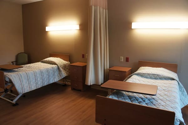 A shared resident room with two beds and a warm ambiance