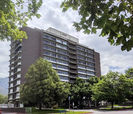 Exterior view of a senior living facility surrounded by trees
