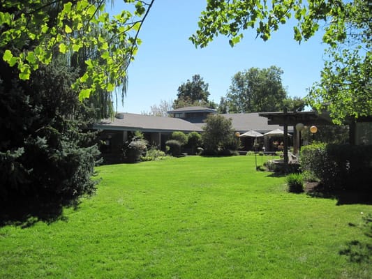 Spacious outdoor area with green lawn and trees