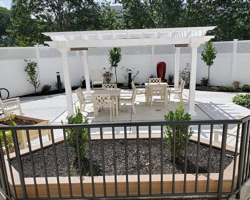 Outdoor seating area with a pergola and landscaped garden