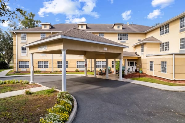 Front entrance of Highland Place with a covered area and landscaped pathway.