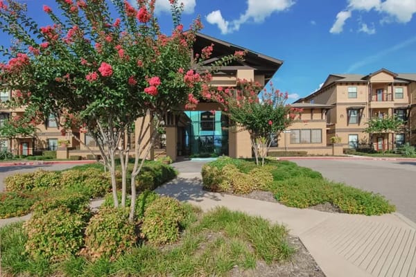 Beautifully landscaped entrance of a senior living facility