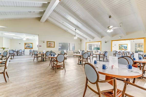 Dining area with tables and chairs set for residents
