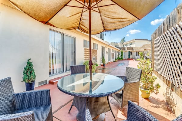 Patio area with tables and chairs under an umbrella