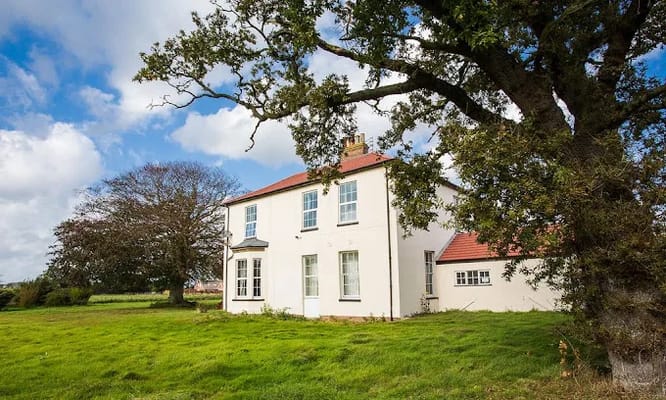 Exterior view of Manor Farm building with greenery