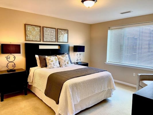 Well-decorated bedroom with a queen bed and bedside lamps