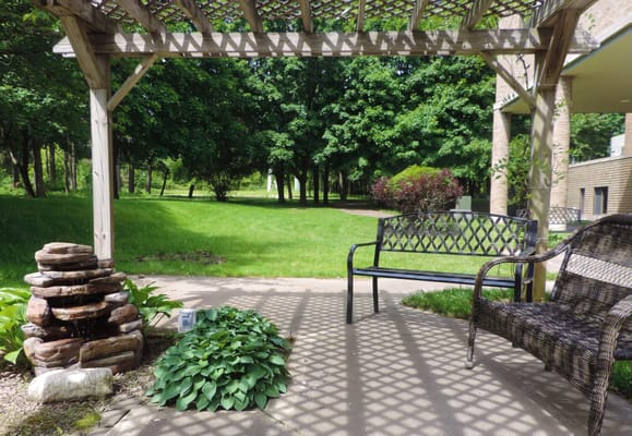 Outdoor seating area with a water feature and greenery