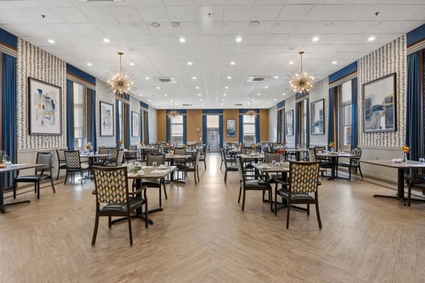 Brightly lit dining room with tables set for meals