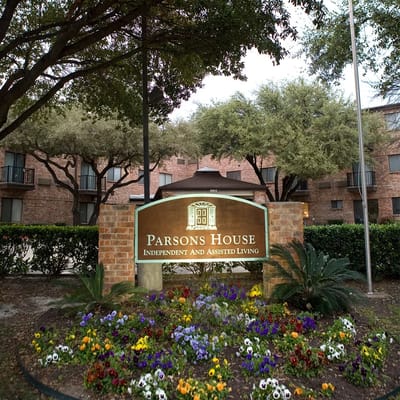 Exterior signage of Parsons House Austin with landscaped flowers