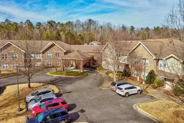 Aerial view of the Regency Pointe senior living facility, featuring parking and landscaped entrance.