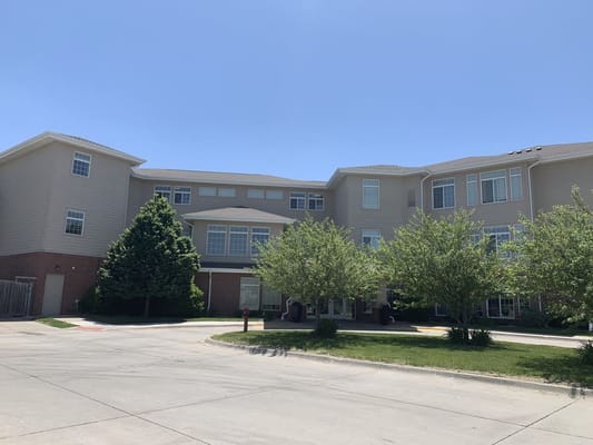 Exterior of Ridgewood Senior Living facility with trees and parking area