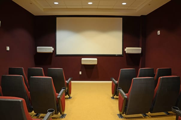 Theater room with seating and a large screen