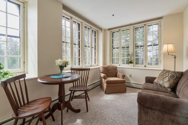 Brightly lit common area with seating and table