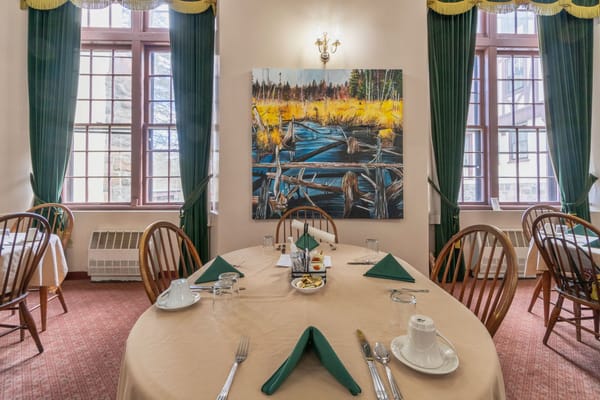 Dining room set for a meal with artwork on the wall