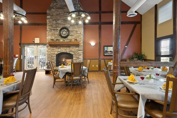 Cozy dining room with wooden beams and stone fireplace