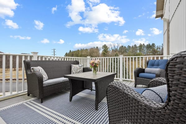 Cozy outdoor seating area with wicker furniture and flowers on a table