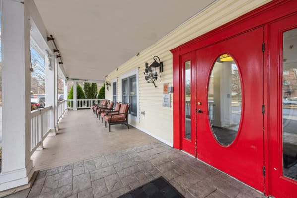 Entrance porch with red door and seating at Seaton Towson