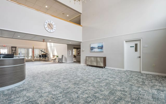Bright lobby area with piano and clock.