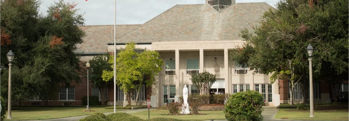Front view of St. Joseph's Assisted Living facility surrounded by greenery.