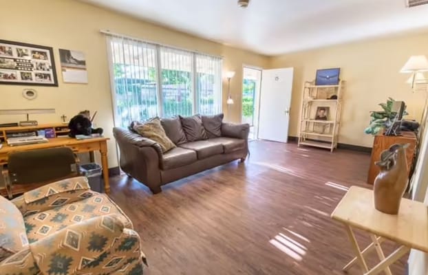 Bright living room with a brown couch and wooden furniture