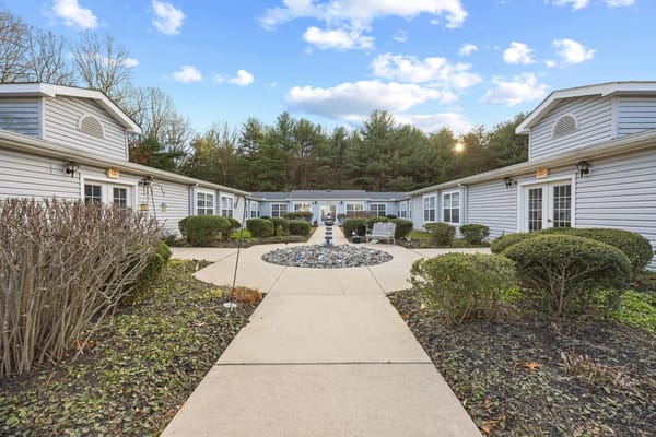 Courtyard featuring landscaped bushes and a stone centerpiece